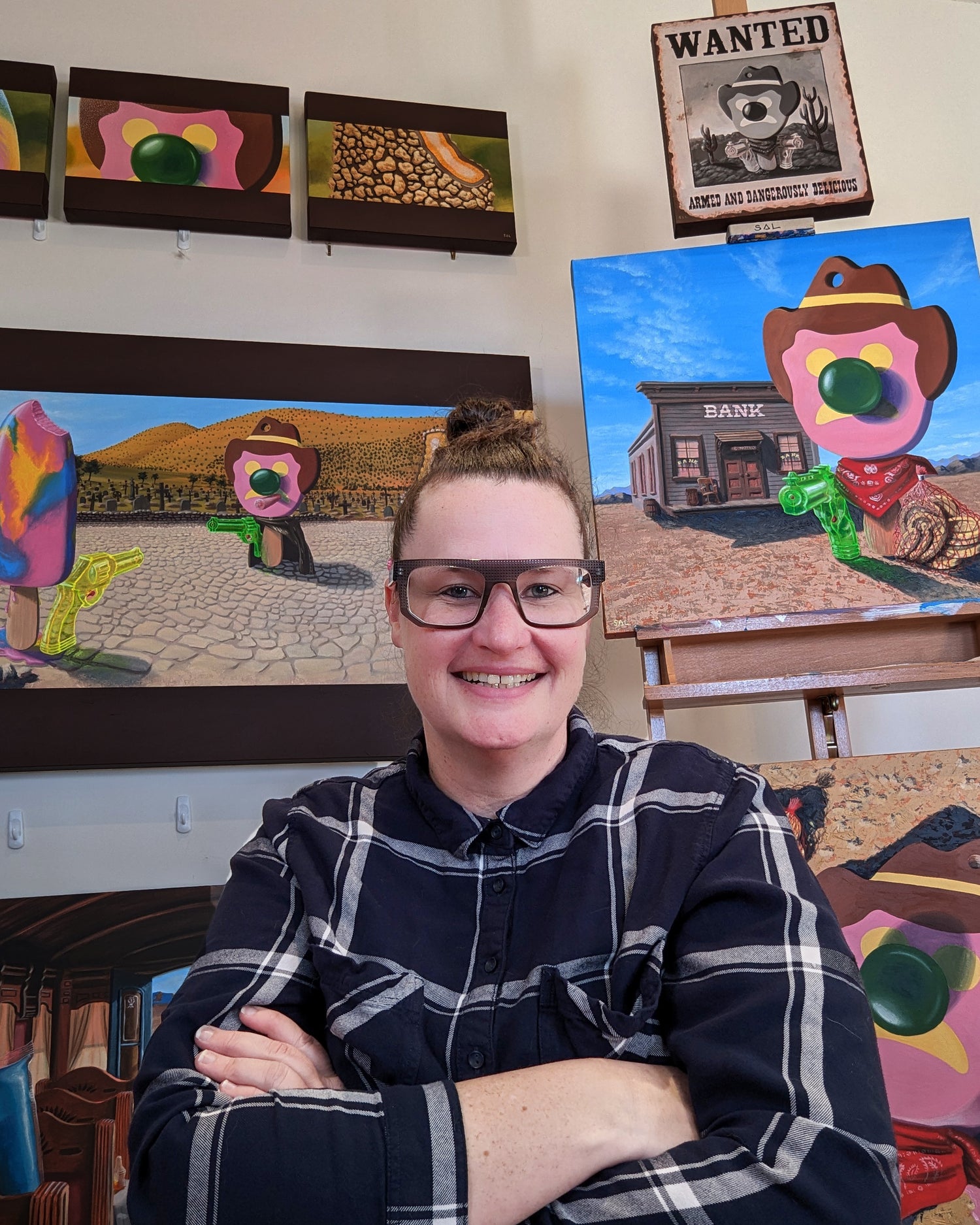 Sally Hastings the artist posing with her bright, colourful pop art original paintings